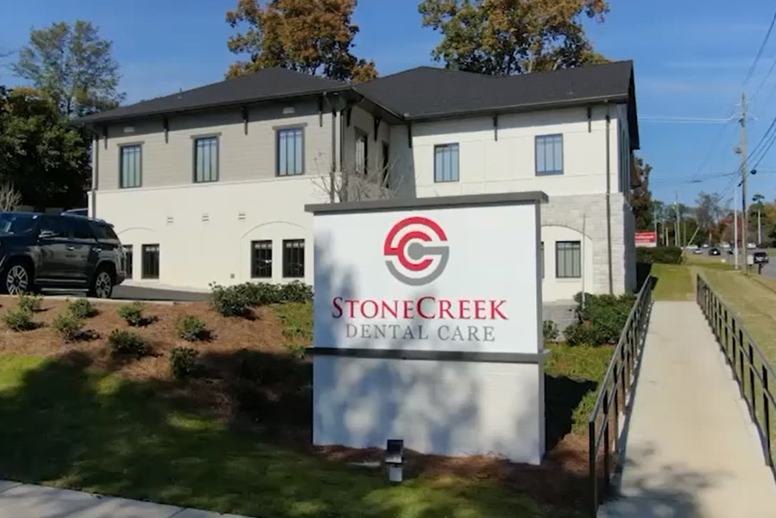 A StoneCreek Dental Care building, with the practice sign by the footpath