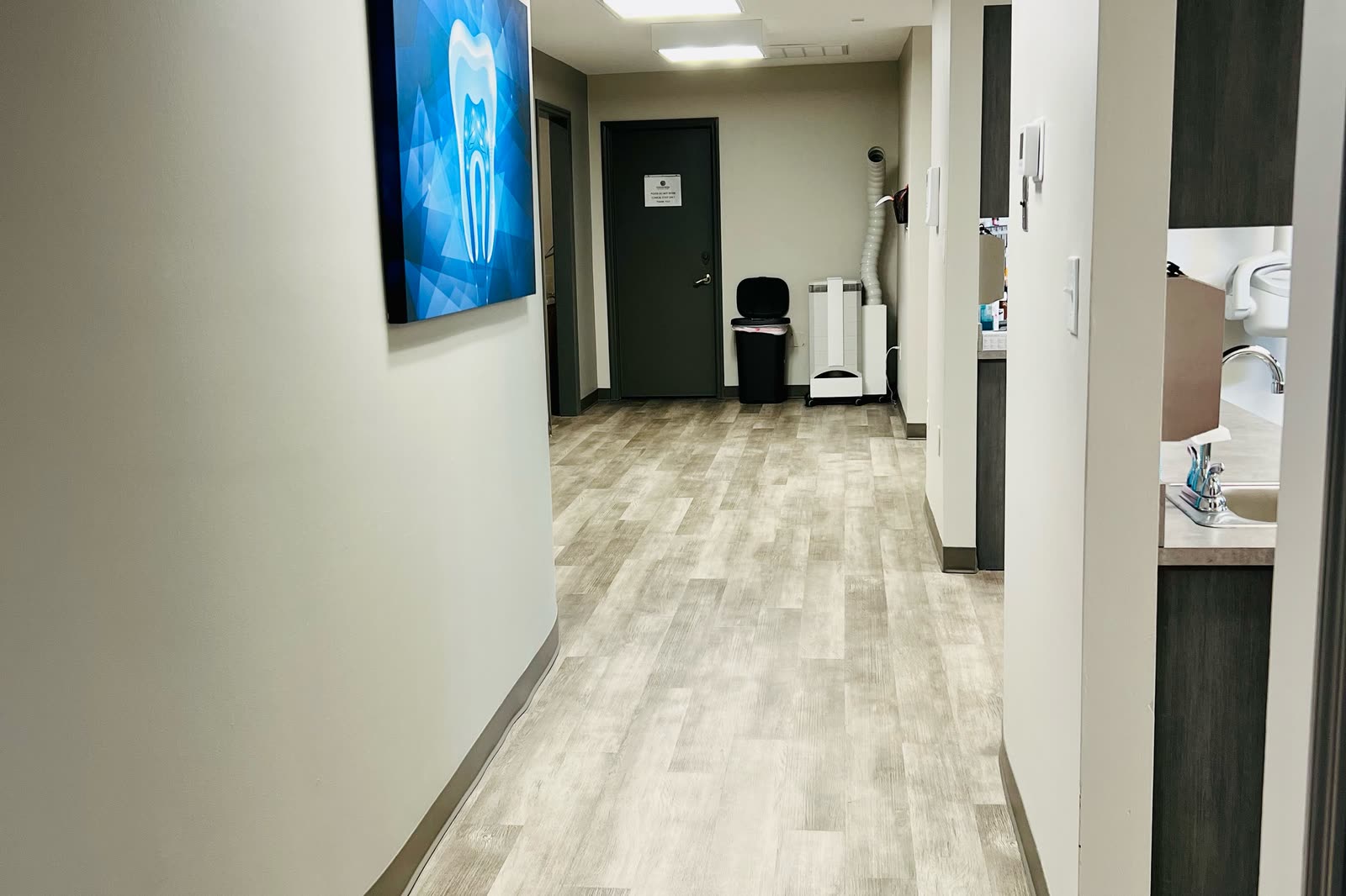 Hallway between treatment rooms, with a picture of a tooth on the curved wall